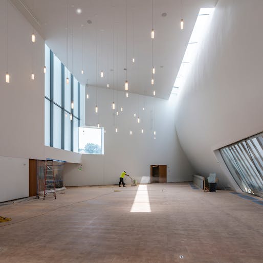 Workers sand the custom parquet floors in the SHA-designed Skylight Pavilion, May 2019. Photo: Jonathan Morefield.