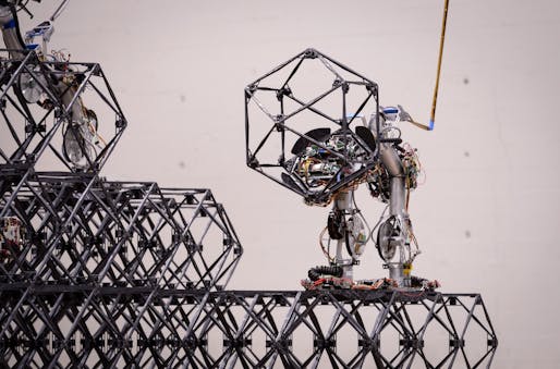A Scaling Omnidirectional Lattice Locomoting Explorer (SOLL-E) builder robot carries a soccer ball-sized building block called a voxel – short for volumetric pixel – during a demonstration of NASA’s Automated Reconfigurable Mission Adaptive Digital Assembly Systems (ARMADAS) technology. Image credit: NASA/Dominic Hart