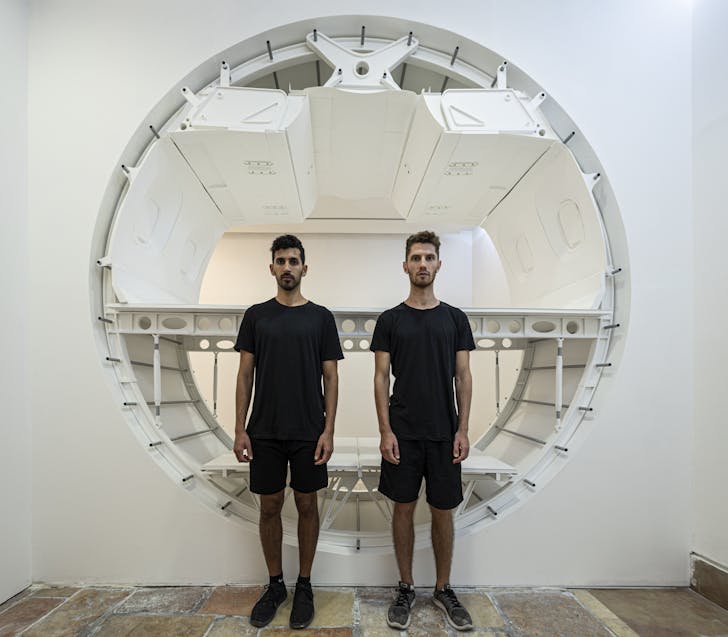 Charles Weinberg and Shai Ben-Ami standing in front of their 1:1 scale model. Image © Michael Shvadron via Charles Weinberg and Shai Ben-Ami