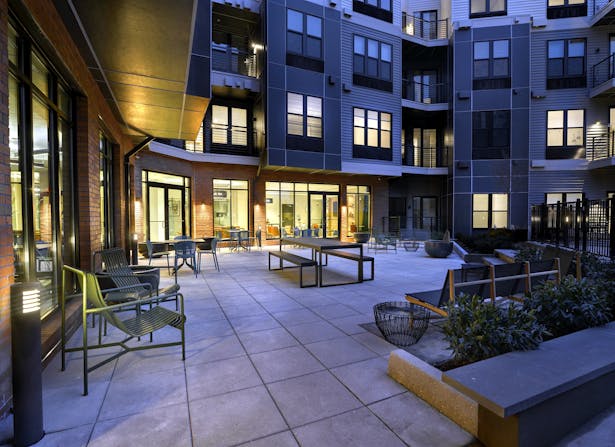 Landscaped outdoor deck at The Mint features a swimming pool, BBQ area and fire pit
