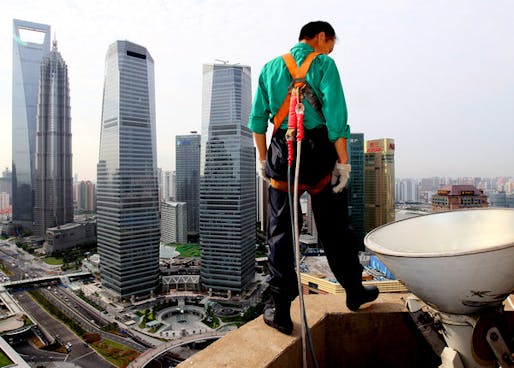 A migrant cleaner on the ledge of a high-rise building in Shanghai. (Photo / Xinhua via chinadaily.com)