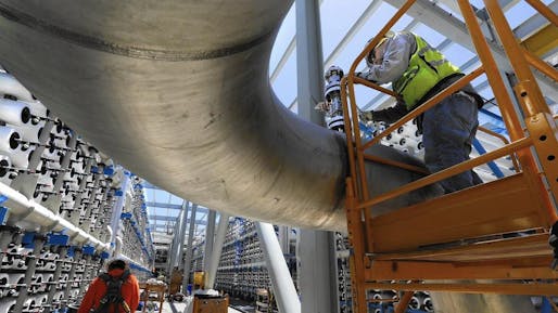 Steven Montes, right, installs a pressure relief valve on a 24-inch stainless steel pipe that will carry desalinated water from the thousands of reverse osmosis filters at the soon-to-be-opened desalination plant in Carlsbad, Calif. (Don Bartletti / Los Angeles Times). Image via latimes.com.