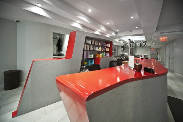 The curves of the reception desk, in Roy Teeluck red, integrates retail displays with the administrative and reception functions of a popular salon.