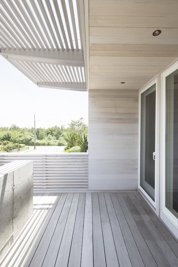 Front porch with poured concrete wall, cedar siding, and cedar brise soleil