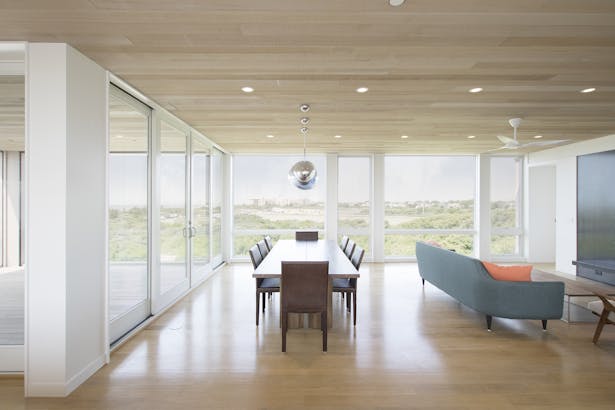 Full height glass lining the dining and living space open to the dunes