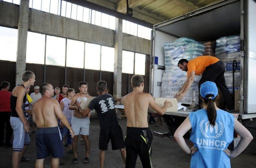 Refugees in E. Ukraine unload supplies provided by the UN. Via: Al Jazeera, Alexander Khudoteply/AFP/Getty Images
