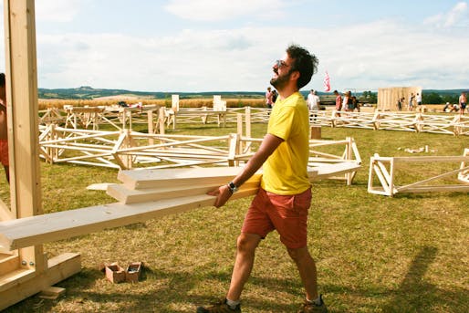 A Hello Wood team member helps build the Project Village (via flickr).