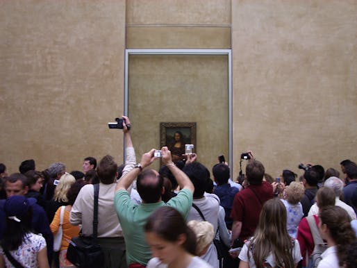 Visitors ogling perhaps the world's most famous painting inside the world's most famous museum. Credit: Wikipedia