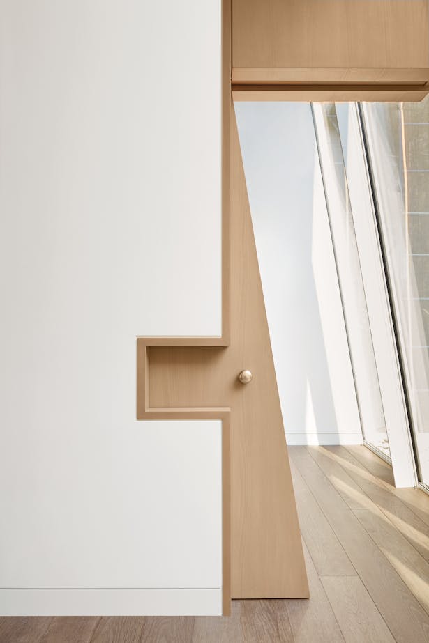 A unique trapezoidal sliding door solves the problem of how to close off an opening formed by a sloping glass façade.