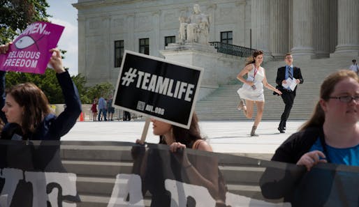Television network producers ran past demonstrators outside of the Supreme Court on Thursday. Credit: Stephen Crowley, image via nytimes.com