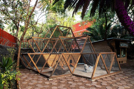 A chicken coop built from salvaged construction waste inspired by Mayan pyramid culture inside a community garden in Mexico City.