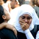 A Muslim woman comforts her Coptic Christian friend who lost a loved one in the Maspero massacre. Credit: Wikipedia