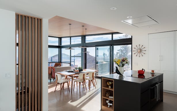Secondary rooms have drywall ceilings creating more intimate spaces and contrasting with the plywood ceiling. The oak screen provides natural light into the small TV nook.