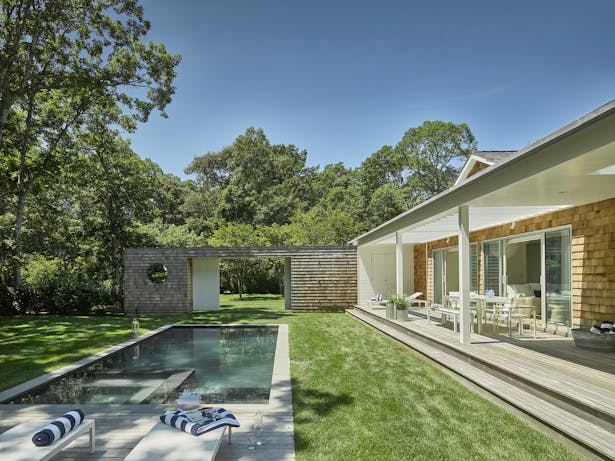 Outside, a large double-thick, cedar-clad wall with a sliding barn entry gate provides privacy from the street, allowing undisturbed enjoyment of the pool and sun deck.