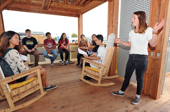 Allie Beck (right) speaks to students on the porch of Clemson University at the U.S. Department of Energy Solar Decathlon at the Orange County Great Park, Irvine, California, Oct. 15. (Credit: Thomas Kelsey/U.S. Department of Energy Solar Decathlon)