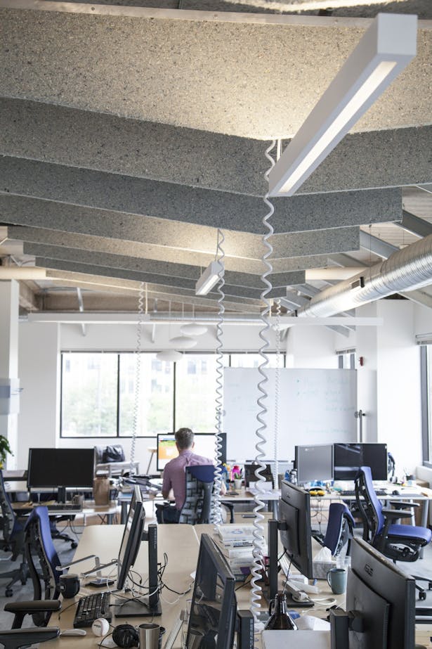 Open office area with custom acoustic baffles fabricated by Synecdoche.