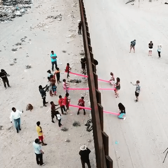 Architects install transnational pink seesaws at U.S.-Mexico border wall
