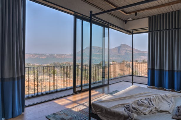 The structural members of the master bedroom were planned with column-free corners to facilitate uninterrupted views of the Sahyadri mountains in the background.
