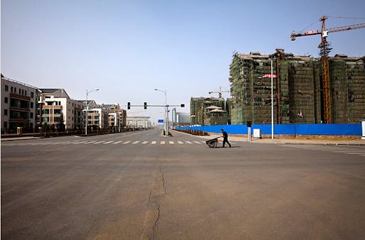 An old man pushes a cart across a road segregating finished apartments and apartments still under construction photo by MICHAEL CHRISTOPHER BROWN FOR TIME