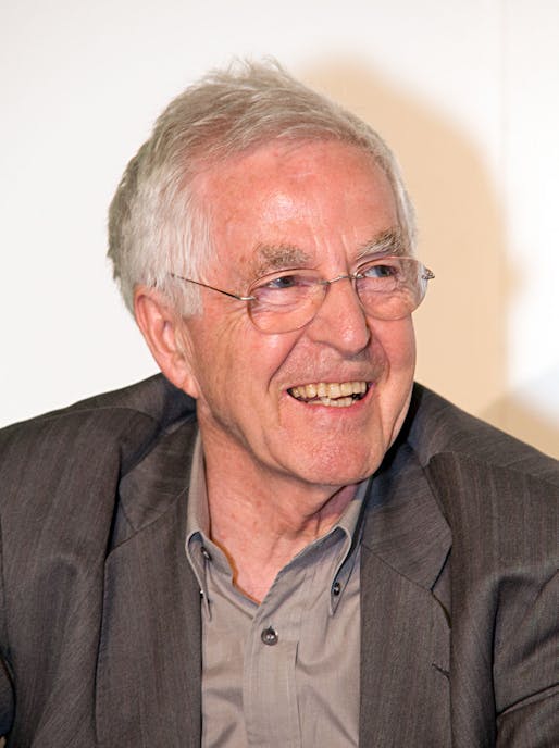 An image via wikimedia.org. Oddly, the caption reads, 'A smiling caucasian male with grey hair, blue eyes, in front of a white background. He is wearing a light grey shirt and dark grey jacket.'