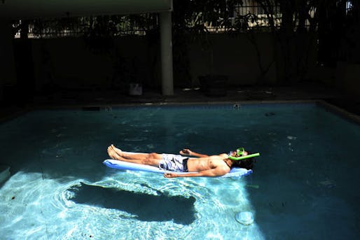 Joseph Lee, 23, a UCLA graduate from Vallejo, teamed up with research partner Benedikt Gross to produce 'The Big Atlas of L.A. Pools.' Here he lounges in one of the blue oases. Susannah Kay / Los Angeles Times.