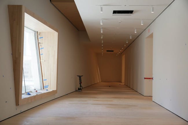 A large window with bench seating is seen though out the expansion in the San Francisco Museum of Modern Art (photo by Lea Suzuki, The SF Chronicle)