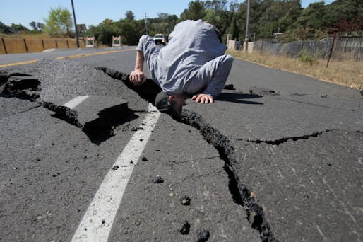 A man sticks his head in a rift opened up in the street by the Napa earthquake. Credit: Lisa James / Register