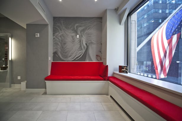 A bold red anchors the reception area against the chaos of the city street.