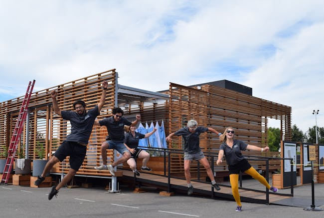 Team members from California Polytechnic State University, San Luis Obispo, kick up their heels during a team cheer at the U.S. Department of Energy Solar Decathlon at the Orange County Great Park, Irvine, California, Monday, Oct. 12, 2015. (Credit: Richard King/U.S. Department of Energy Solar Decathlon)